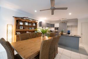 - une salle à manger et une cuisine avec une table et des chaises en bois dans l'établissement Beach bliss, Netflix,Wifi, à Kewarra Beach