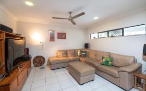 een woonkamer met een bank en een flatscreen-tv bij Beach bliss, Netflix,Wifi in Kewarra Beach