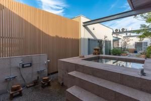 un patio trasero con piscina profunda y un edificio en Bijou Suites AI PREMIUM en Osaka