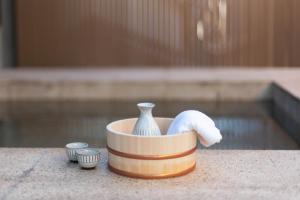 um pequeno recipiente com um vaso ao lado de uma piscina em Bijou Suites AI PREMIUM em Osaka