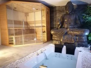 a large statue of a buddha in a bathroom at Jacuzzi Romantique 15 min Etretat 2 in Fécamp