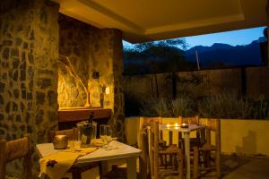 2 Tische und Stühle in einem Restaurant mit Fenster in der Unterkunft Las Espuelas Casas de Montaña in Potrerillos