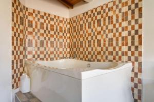 a bath tub in a bathroom with a tiled wall at Poblado Brownstone in Medellín