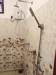 y baño con ducha y cabezal de ducha. en Ranmitha Villa, en Weligama