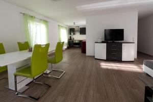 an office with a desk and chairs and a tv at Ferienwohnungen auf der Schleusenhalbinsel in Woltersdorf +1 photo