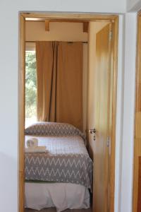 a small bedroom with a bed with a mirror at El Arrayan in Villa Pehuenia