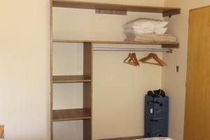 Schlafzimmer mit Holzregalen und einem Bett in einem Zimmer in der Unterkunft El Arrayan in Villa Pehuenia