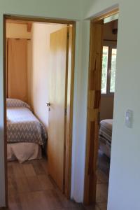 Habitación con dormitorio con cama y puerta en El Arrayan en Villa Pehuenia