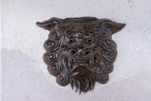 a metal object with an owl on a wall at kamekamehouse in Tokashiki