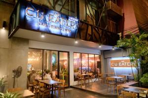 a restaurant with tables and chairs in a building at C U Inn Bangkok in Bangkok