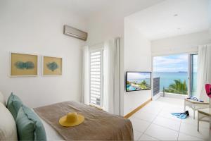 a room with a bed and a view of the ocean at Myra Seafront Suites with LOV in Cap Malheureux