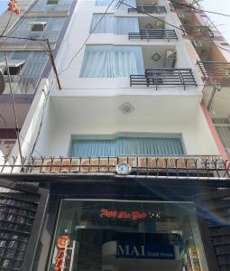 una tienda frente a un edificio con un cartel en la ventana en Mai Guest House, en Ho Chi Minh