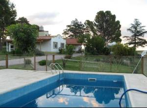 a blue swimming pool in front of a house at La Candelaria - Casas de Campo - in Sierra de la Ventana