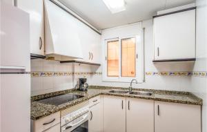 a kitchen with white cabinets and a sink at Awesome Apartment In Blanes in Blanes