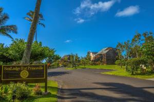 een bord aan de kant van een weg met een palmboom bij Oceanfront Condo with panoramic views! in Princeville