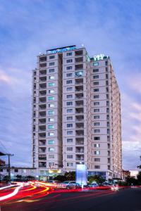 a tall white building with a sign on top of it at MekongView 1 CondoTel in Phnom Penh