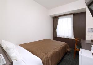 a hotel room with a bed and a window at Hotel Trend Okayama Ekimae in Okayama