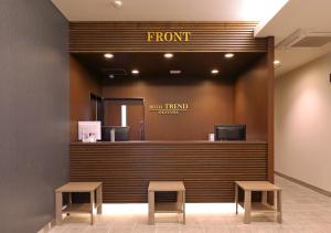 a front counter of a hotel with two stools at Hotel Trend Okayama Ekimae in Okayama