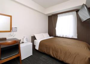 Hotel Trend Okayama Ekimae في أوكاياما: غرفه فندقيه بسرير ونافذه