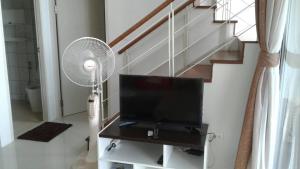 a room with a tv and a fan and stairs at GrandBeach Duplex Sea view by malai in Ban Tha Fat