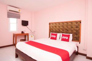 um quarto com uma cama grande e 2 almofadas vermelhas em OYO 587 Baan Taklom Chomtalay em Cha Am