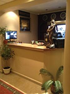 a lobby with a bar with a statue on it at Hotel Romantic in Sofia