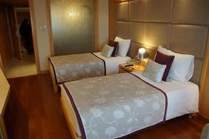 a hotel room with two beds and a lamp at Jaypee Vasant Continental in New Delhi