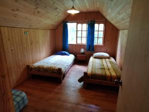 um quarto com 2 camas numa casa de madeira em Cabaña Radal en Coñaripe cerca del lago Calafquén em Coñaripe