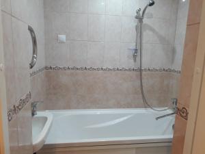 a bathroom with a bath tub with a shower at Teatra 32 in Daugavpils