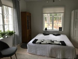 a bedroom with a bed and two windows at Villa Tammikko in Tuusula