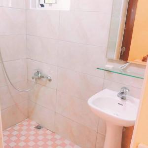 a white bathroom with a sink and a shower at Pu Shi Homestay in Yuli
