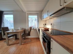 a kitchen with a wooden table and a wooden counter top at FeWo-Butze 3 Deichblick Strandnähe ca. 750m in Dornumersiel