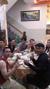un grupo de personas sentadas alrededor de una mesa comiendo en khach san thu thanh ly son, en Quảng Ngãi