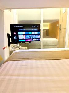 a bedroom with a bed and a television in a mirror at Front One Cabin Sunter in Jakarta