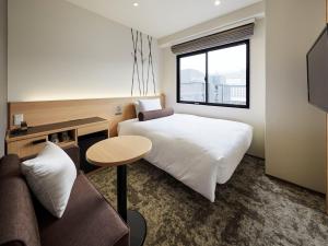 Royal Twin Hotel Kyoto Hachijoguchi tesisinde bir odada yatak veya yataklar