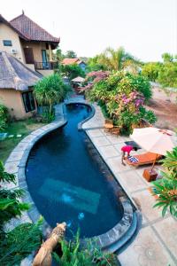 a swimming pool in front of a house at Pondok Mimpi Tulamben in Tulamben