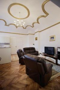 a living room with a couch and a television at Little Vienna Gold Apartment in Varaždin