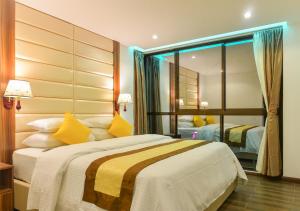 sypialnia z dużym łóżkiem z żółtymi poduszkami w obiekcie Dreams Grand w mieście Hulhumale