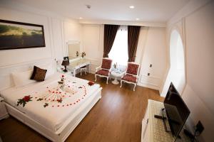 a hotel room with a large bed and a television at HANZ Premium Mai Vang Hotel in Da Lat