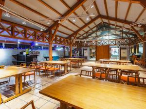 Tabist Villa Daio Resort Ise-Shima في شيما: مطعم فارغ بطاولات وكراسي خشبية