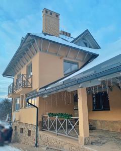 a house with a roof that has a balcony at M.A.K.home in Vyshka