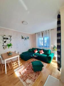 een woonkamer met een groene bank en een tafel bij Apartman Zlatibor spa in Zlatibor
