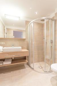 ein Bad mit einer Dusche und einem Waschbecken in der Unterkunft Hotel Salzburger Hof in Dienten am Hochkönig