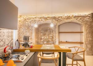 a kitchen with a table with chairs and a stove at Archimede apartments in Siracusa
