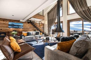 uma sala de estar com sofás e mesas em Manali Lodge by Alpine Residences em Courchevel