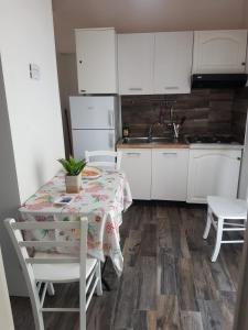 - une cuisine avec une table, des chaises et un évier dans l'établissement Lipari Centro Storico Flat 5 mins from Port, à Lipari