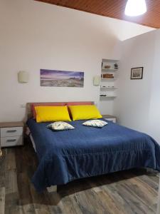 - une chambre avec un lit doté d'une couverture bleue et d'oreillers jaunes dans l'établissement Lipari Centro Storico Flat 5 mins from Port, à Lipari