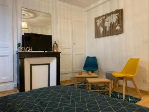 a living room with a fireplace and two chairs at So Amiens in Amiens