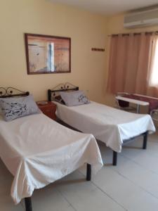 Habitación hospitalaria con 2 camas y espejo en Naama rooms for rent en Neve Zohar