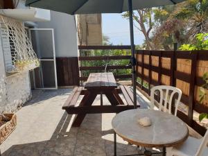 una mesa de picnic y una sombrilla en el patio en Naama rooms for rent en Neve Zohar
